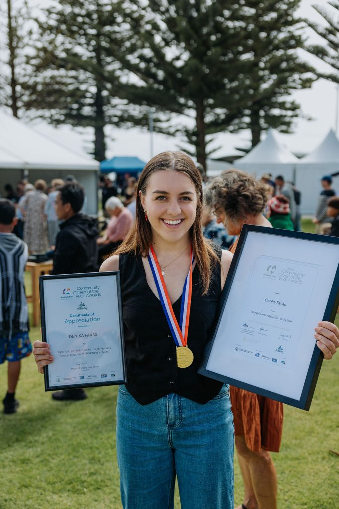 young woman holding certificates and smiling to camera