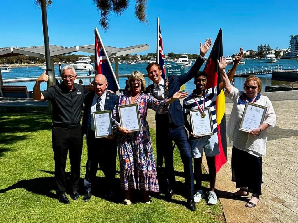 group of people holding certificates and smiling into camera