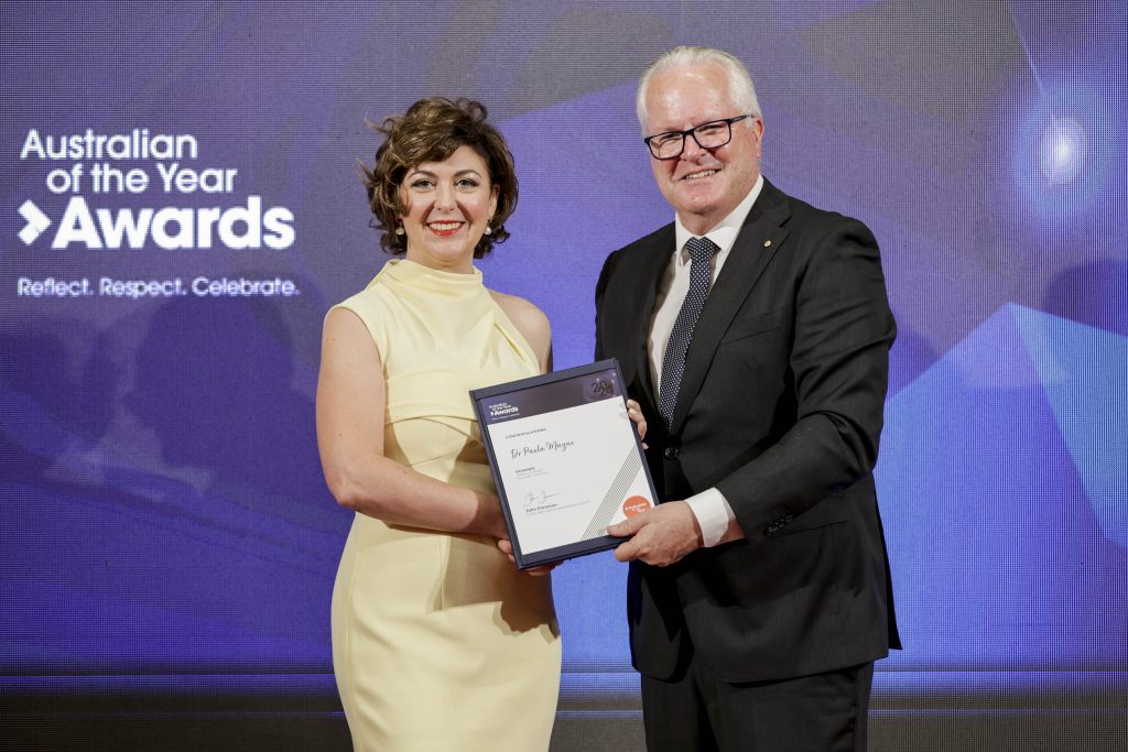 woman and man on stage holding certificate