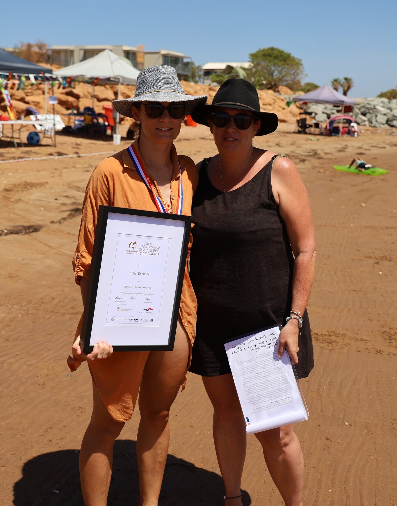 two women standing in outback smiling to camera