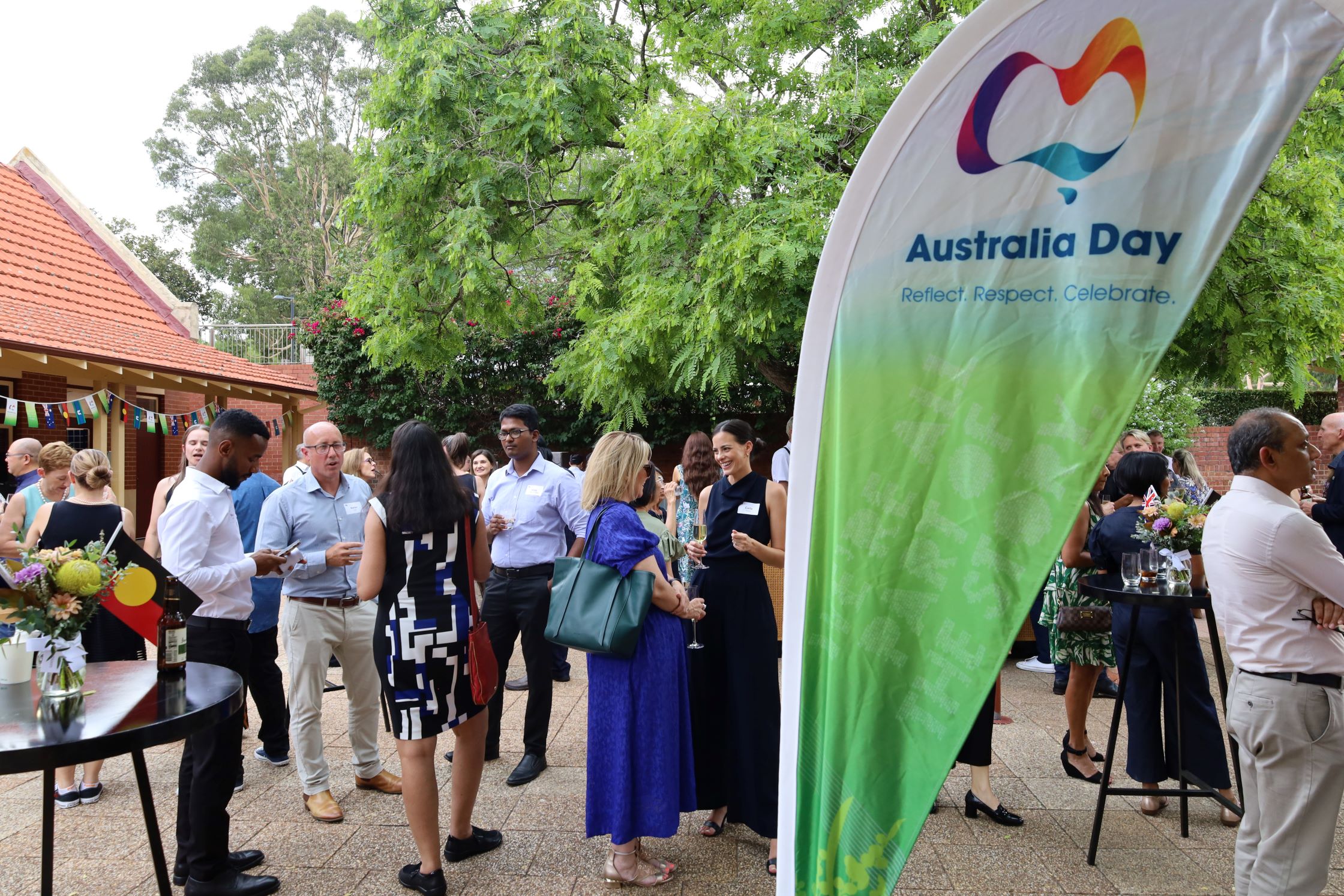 people at event with Australia Day flag in foreground