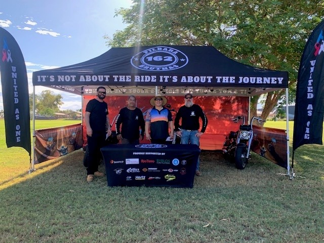 four men standing under gazebo