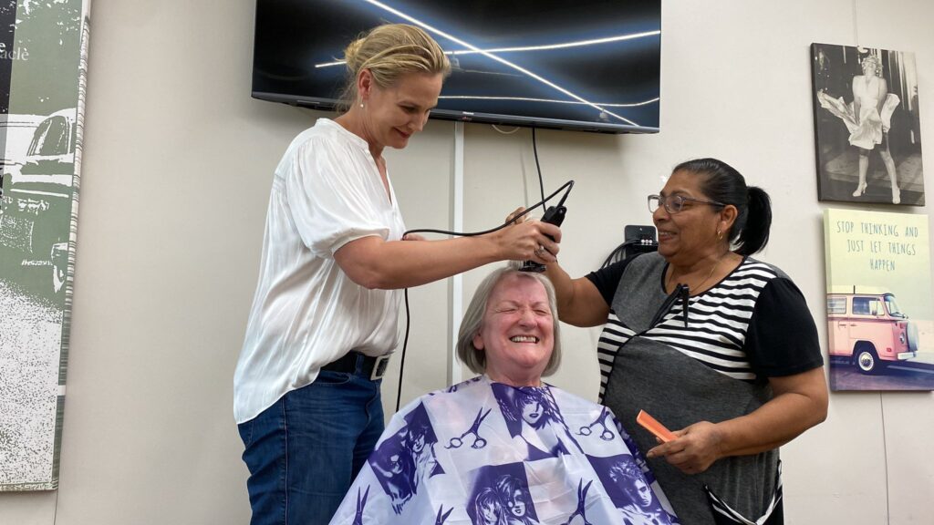 monika wong having her head shaved by two women
