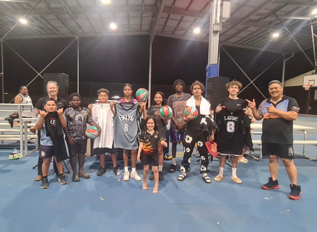 group of children on basketball court smiling to camera