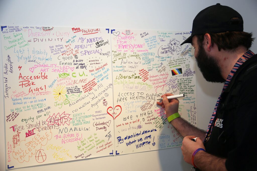 person writing on board filled with messages
