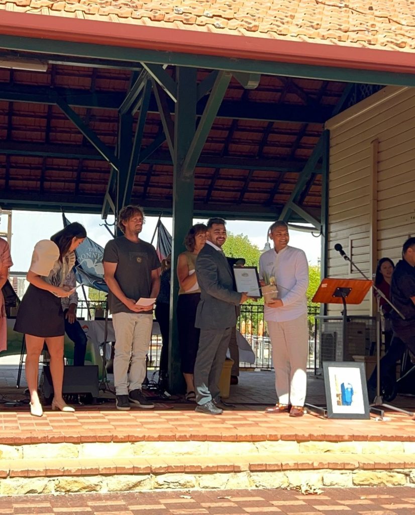 people on stage with two men holding certificate