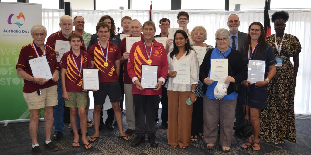 large group of people smiling to camera, many holding certificates