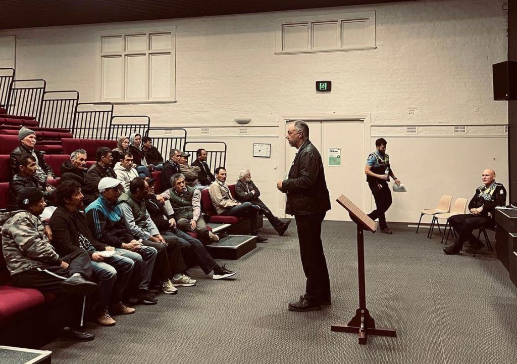 man speaking to group in auditorium