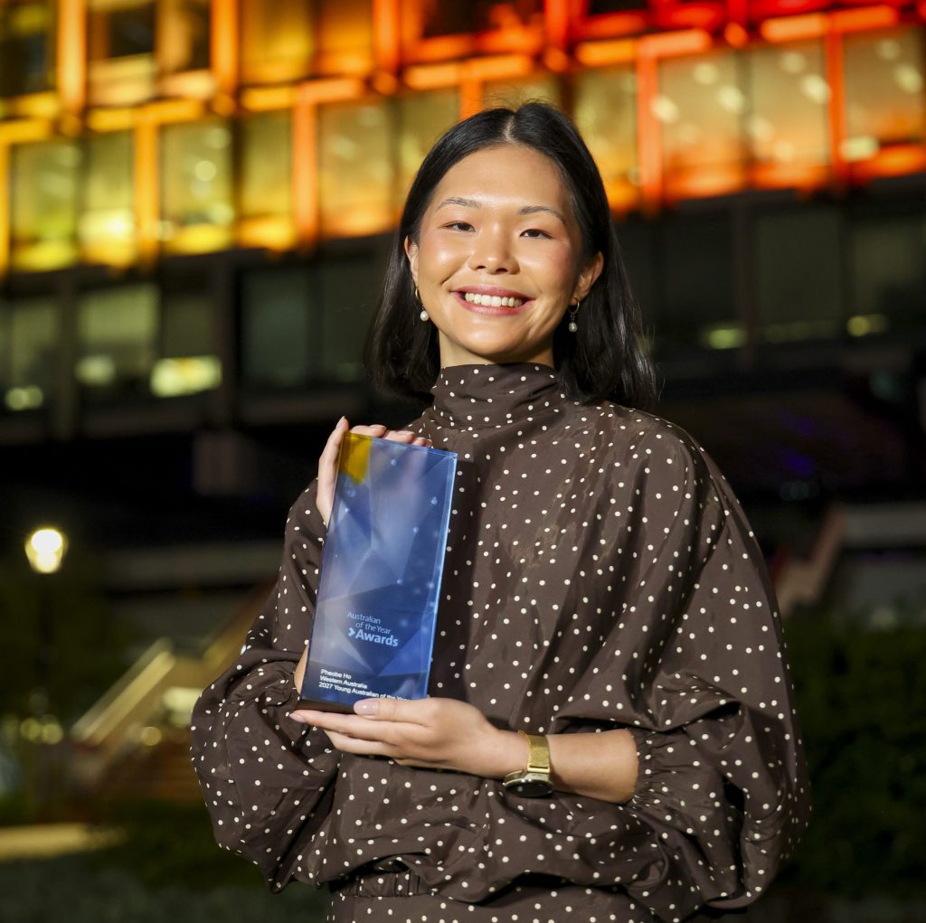 Pheobe Ho holding award and smiling to camera